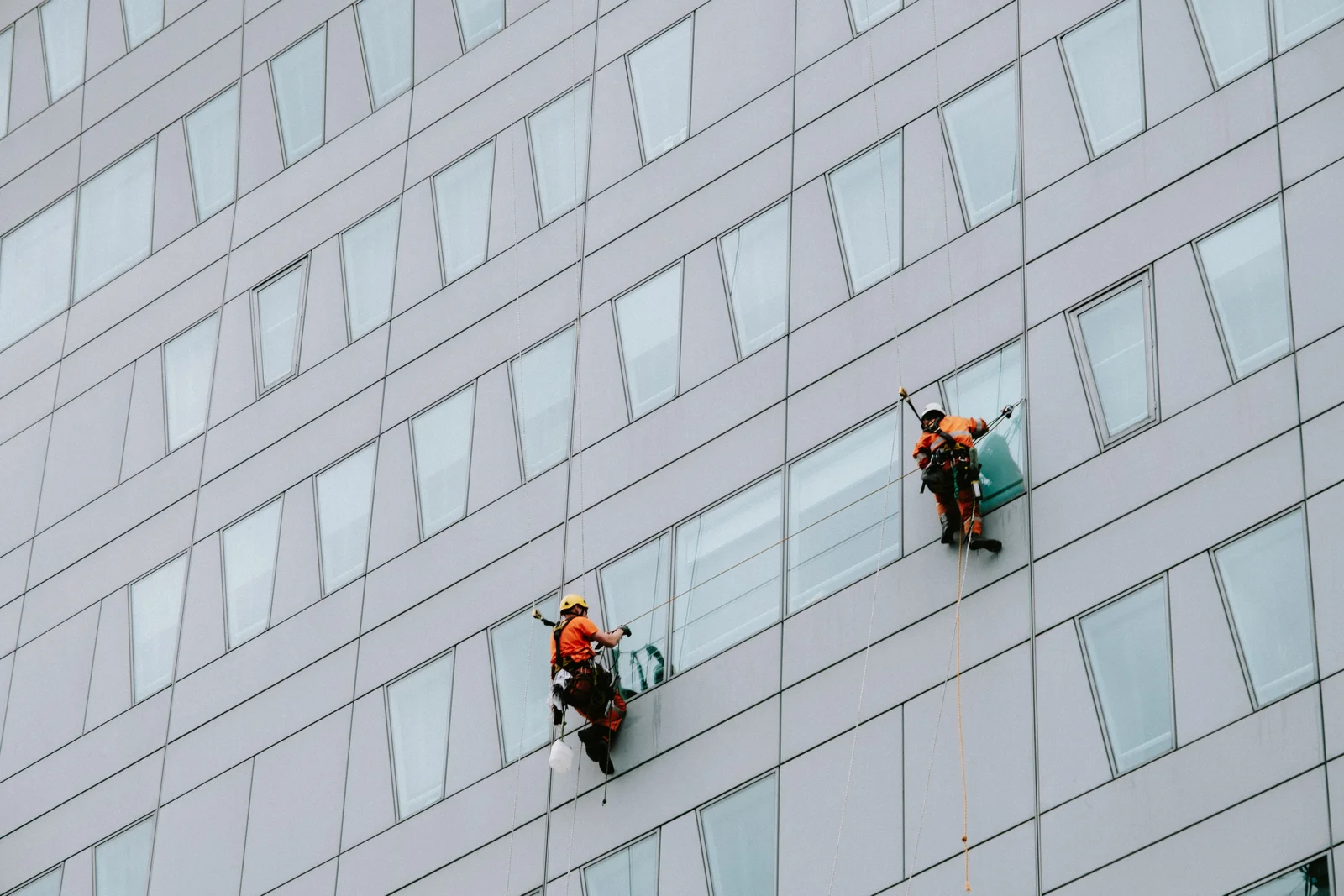 Professional construction cleaning workers carrying out facade cleaning on a commercial building