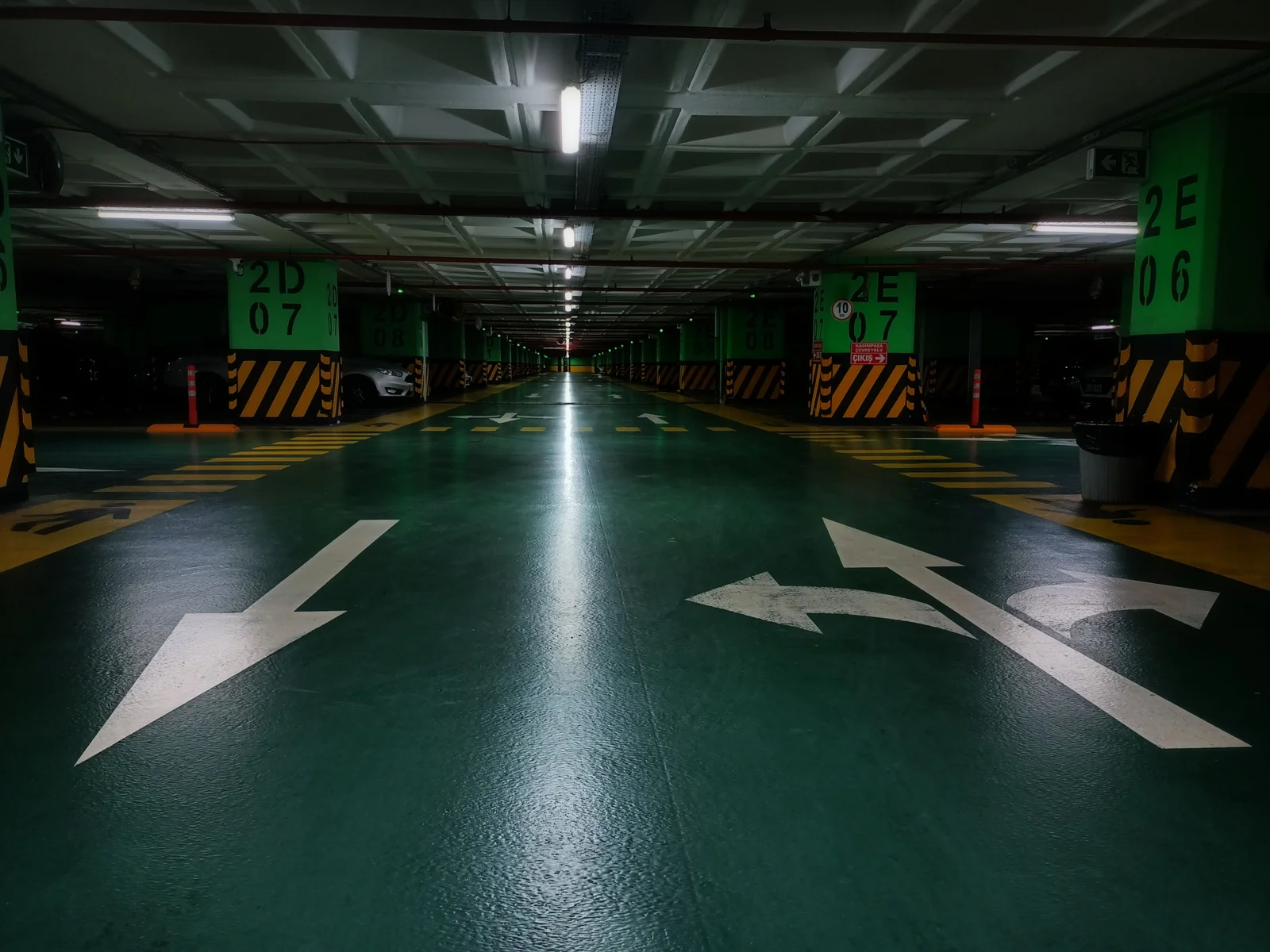 Completed underground car park with sealed floor and clearly marked traffic direction arrows