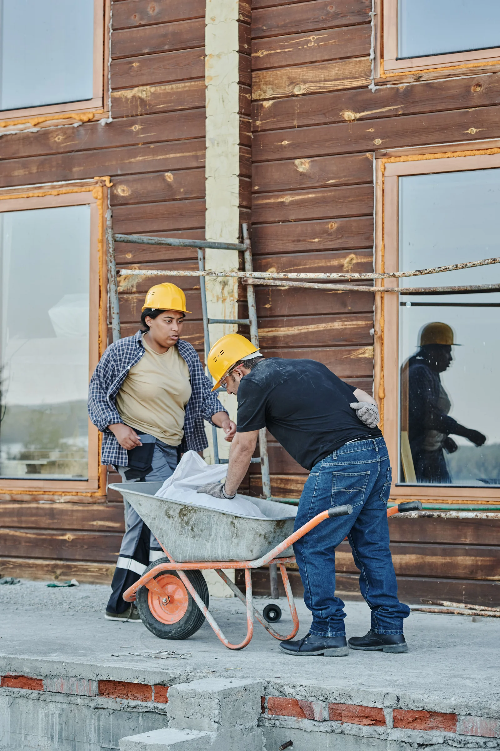 Construction workers wearing safety helmets and protective equipment while working at a construction site